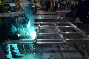 Welder fitting an aluminum frame for datacenters