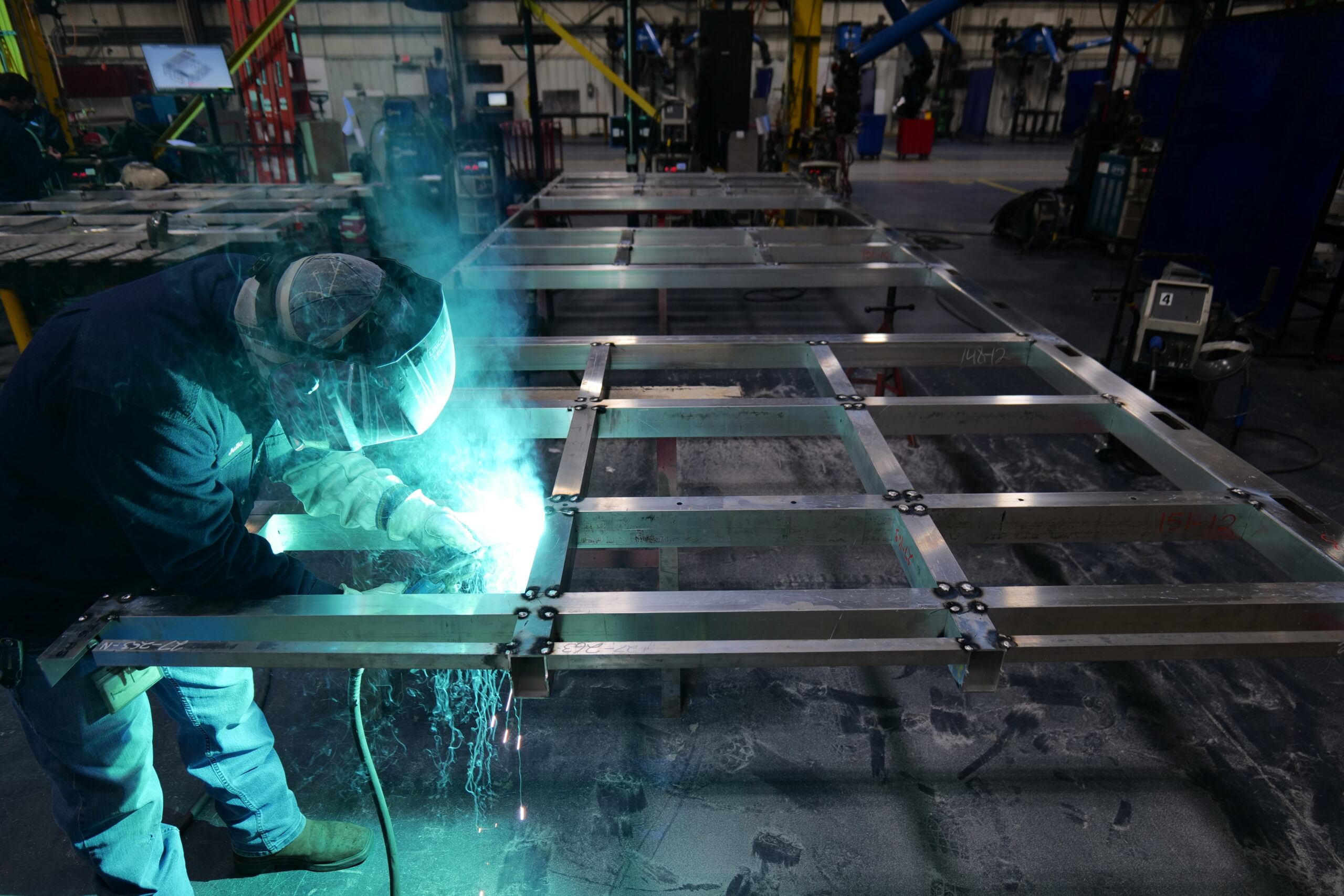 Welder fitting an aluminum frame for datacenters